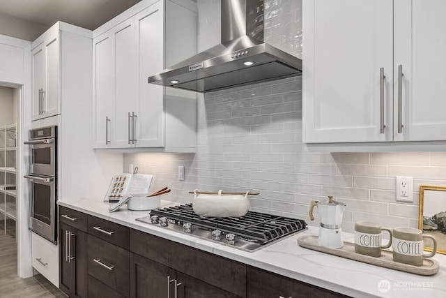 13212 164th Ave SE Unit 207, Renton, WA 98059 - kitchen with wall chimney exhaust hood, appliances with stainless steel finishes, white cabinetry, and light stone countertops