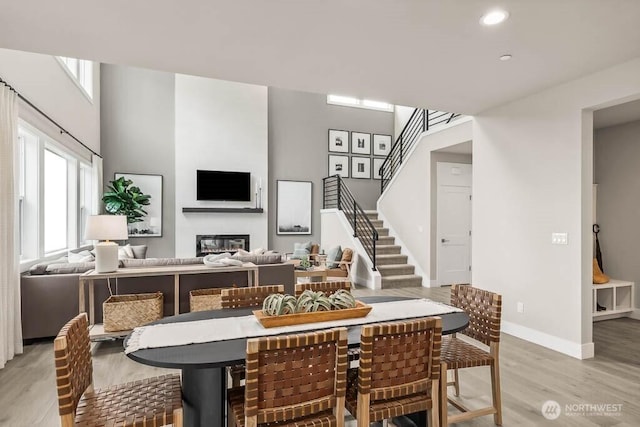 13212 164th Ave SE Unit 207, Renton, WA 98059 - dining area featuring light wood finished floors, a glass covered fireplace, recessed lighting, and stairs
