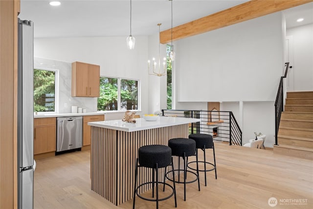 13652 99th Ave NE, Kirkland, WA 98034 - kitchen with dishwasher, light countertops, light wood-style floors, a kitchen bar, and a kitchen island