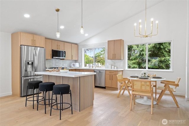 13652 99th Ave NE, Kirkland, WA 98034 - kitchen with stainless steel appliances, light brown cabinetry, light wood-style floors, tasteful backsplash, and a kitchen bar