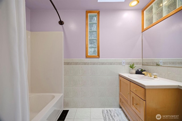 347 W King Tut Rd, Bellingham, WA 98226 - full bathroom with vanity, tile patterned flooring, tile walls, shower / bathtub combination with curtain, and a wainscoted wall