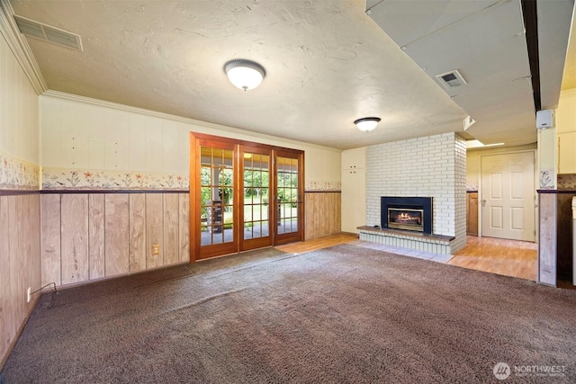 347 W King Tut Rd, Bellingham, WA 98226 - unfurnished living room with a fireplace, a textured ceiling, wooden walls, a wainscoted wall, and carpet