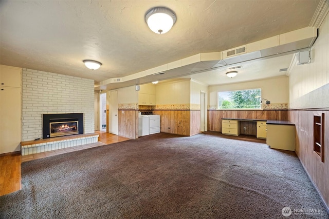 347 W King Tut Rd, Bellingham, WA 98226 - unfurnished living room with washer and dryer, a fireplace, a wainscoted wall, carpet flooring, and wooden walls