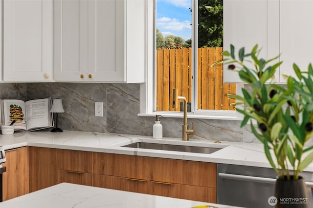 7605 20th Ave E, Tacoma, WA 98404 - kitchen with stainless steel dishwasher, tasteful backsplash, light stone counters, and white cabinetry