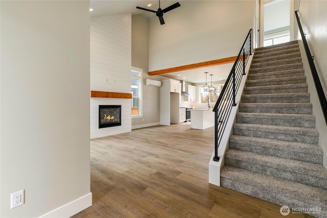 2632LOT13 Sievers Way, Ferndale, WA 98248 - stairway with a high ceiling, a wall mounted air conditioner, a large fireplace, healthy amount of natural light, and wood finished floors