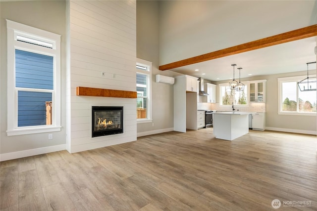 2632LOT13 Sievers Way, Ferndale, WA 98248 - unfurnished living room with an AC wall unit, light wood-style floors, recessed lighting, a large fireplace, and a chandelier