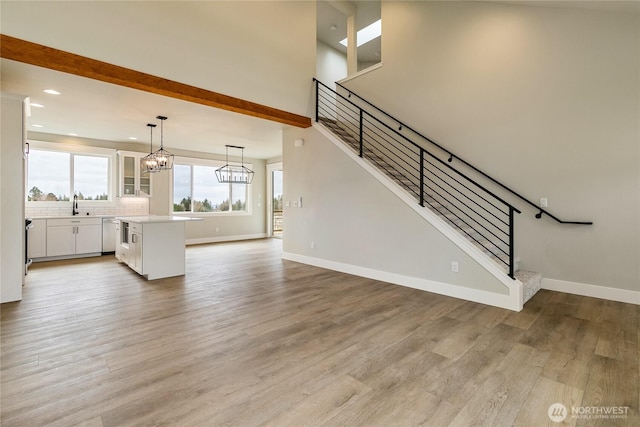 2632LOT13 Sievers Way, Ferndale, WA 98248 - unfurnished living room featuring stairway, light wood-style floors, recessed lighting, a chandelier, and beamed ceiling