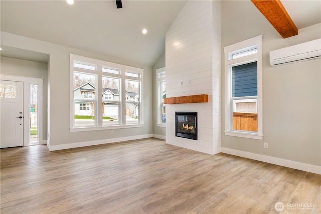2632LOT13 Sievers Way, Ferndale, WA 98248 - unfurnished living room featuring a wall mounted AC, light wood-type flooring, a fireplace, recessed lighting, and high vaulted ceiling