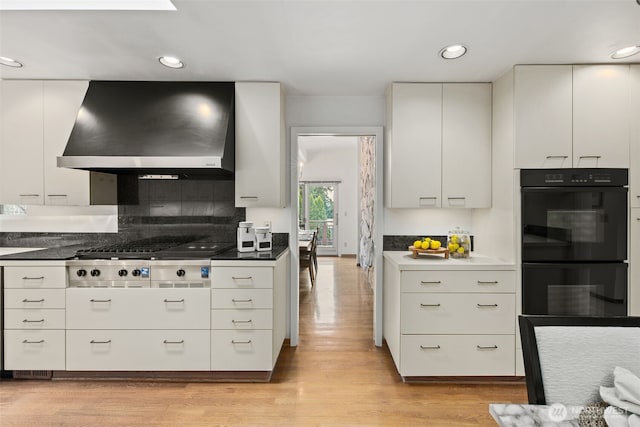 3015 44th Ave W, Seattle, WA 98199 - kitchen featuring extractor fan, stainless steel gas cooktop, light wood-style floors, white cabinetry, and recessed lighting