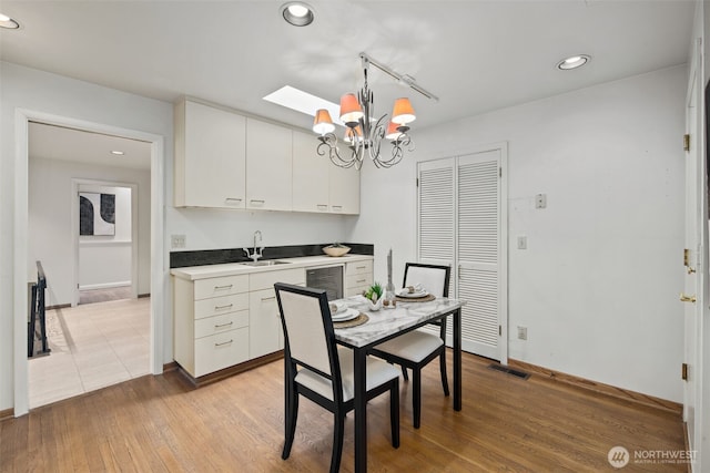 3015 44th Ave W, Seattle, WA 98199 - dining area with a chandelier, beverage cooler, light wood-style floors, recessed lighting, and a skylight