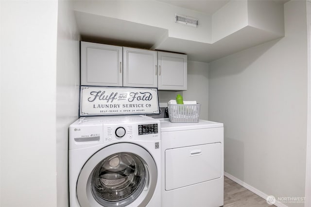 110 S 198th Pl, Des Moines, WA 98148 - laundry room with cabinet space, washer and dryer, and light wood-type flooring