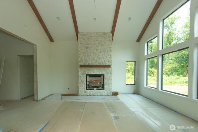 12107 Mundy Loss Rd E, Buckley, WA 98321 - unfurnished living room featuring high vaulted ceiling, beamed ceiling, healthy amount of natural light, and a stone fireplace