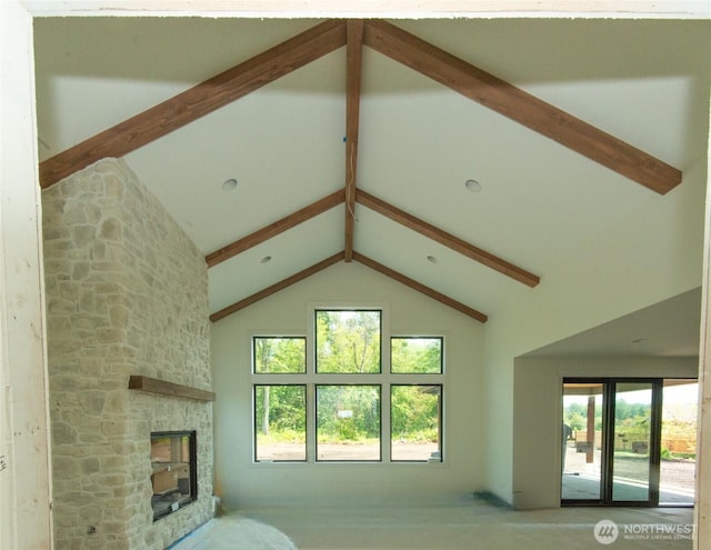 12107 Mundy Loss Rd E, Buckley, WA 98321 - unfurnished living room featuring beam ceiling, plenty of natural light, a stone fireplace, and high vaulted ceiling