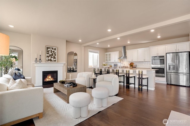 4418 233rd Pl SE, Bothell, WA 98021 - living area with plenty of natural light, recessed lighting, dark wood-style flooring, arched walkways, and a tiled fireplace