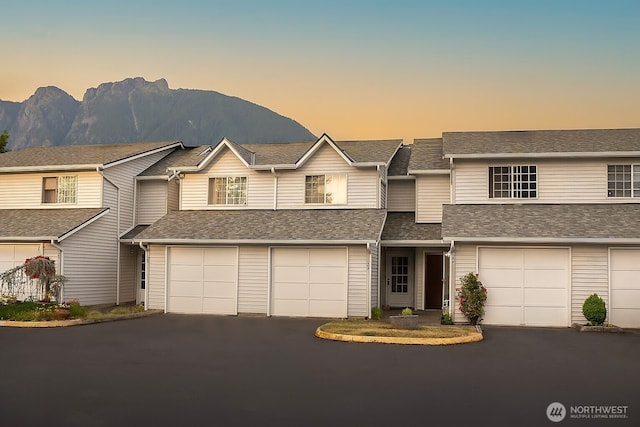 315E Park St Unit A22, North Bend, WA 98045 - townhome / multi-family property featuring driveway, a mountain view, a garage, and a shingled roof