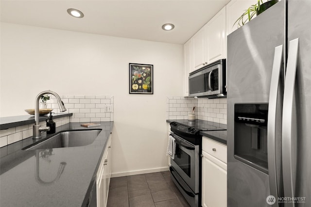 500 Aloha St Unit 202, Seattle, WA 98109 - kitchen featuring appliances with stainless steel finishes, backsplash, white cabinetry, dark tile patterned flooring, and recessed lighting