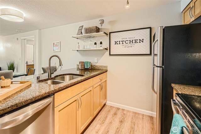 3045 20th Ave W Unit 108, Seattle, WA 98199 - kitchen featuring appliances with stainless steel finishes, light wood-style flooring, dark stone countertops, light brown cabinetry, and open shelves