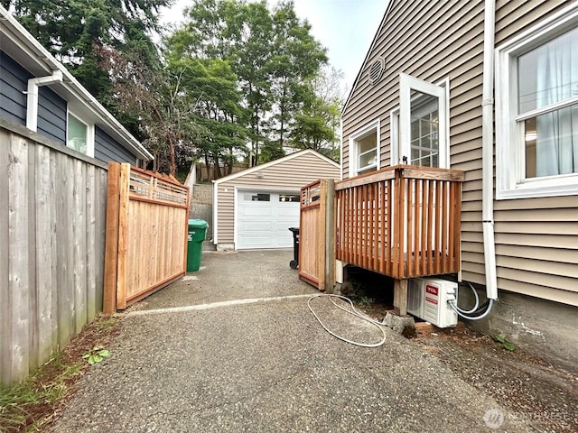 7353 29th Ave SW, Seattle, WA 98126 - view of patio with asphalt driveway, an outbuilding, a garage, and a wooden deck