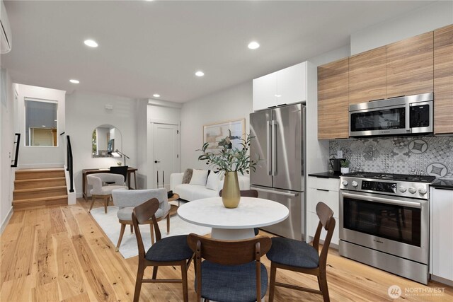 2439 NW 61st St Unit A, Seattle, WA 98107 - dining area with stairway, recessed lighting, a wall mounted AC, light wood-style floors, and arched walkways