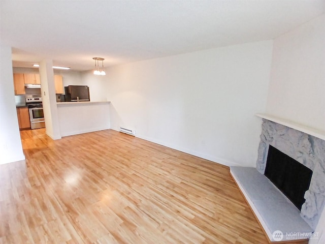 510 S 325th St Unit 19G, Federal Way, WA 98003 - unfurnished living room with light wood finished floors, a baseboard heating unit, and a fireplace