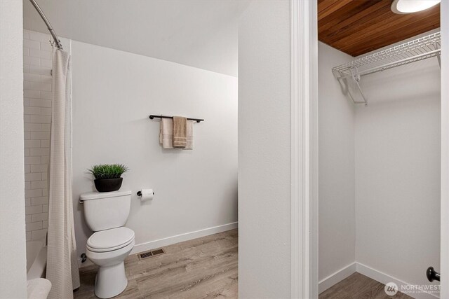 12718 NE 120th St Unit J-2, Kirkland, WA 98034 - full bathroom featuring wood finished floors, shower / bath combo with shower curtain, and a spacious closet