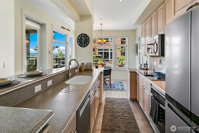 1900 Alaskan Way Unit 116, Seattle, WA 98121 - kitchen featuring stainless steel appliances, light brown cabinets, pendant lighting, and light tile patterned floors