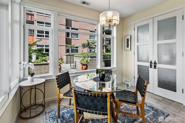 1900 Alaskan Way Unit 116, Seattle, WA 98121 - dining space with french doors, wood finished floors, and a chandelier