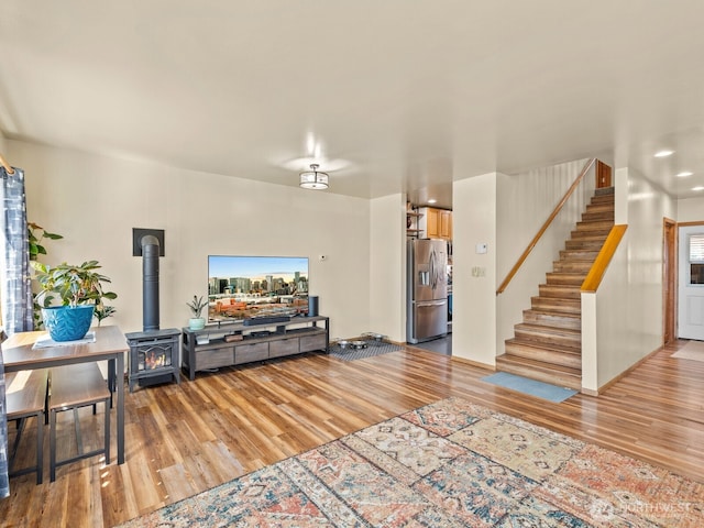 139 Maple St, Camano Island, WA 98282 - living room featuring wood finished floors, stairway, and a wood stove