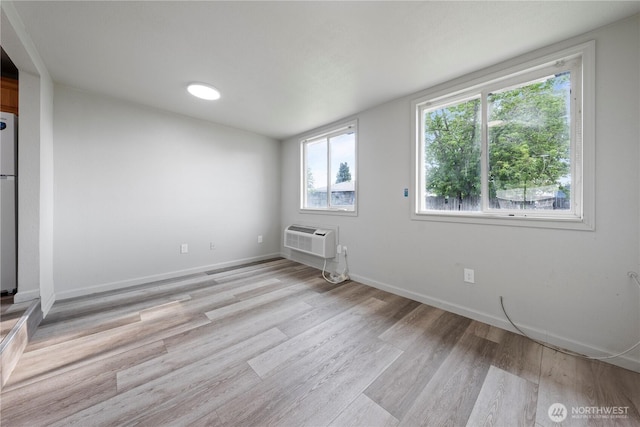 325 S 8th Ave, Othello, WA 99344 - unfurnished living room featuring a wall unit AC and light wood-style floors