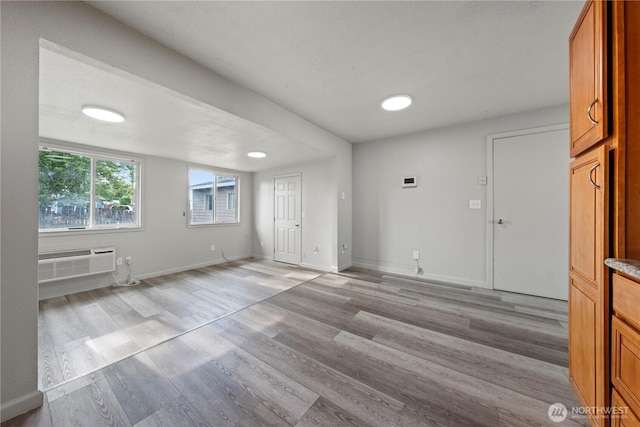 325 S 8th Ave, Othello, WA 99344 - unfurnished living room with a wall unit AC and light wood-style floors