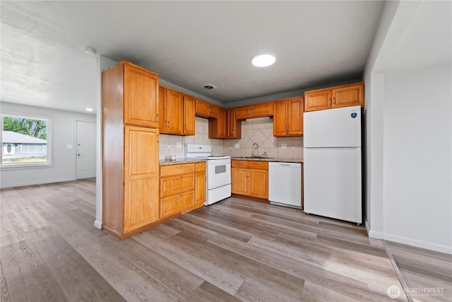 325 S 8th Ave, Othello, WA 99344 - kitchen featuring white appliances, wood finished floors, backsplash, and light countertops