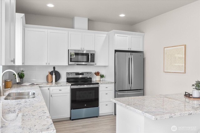 711 S 96th St, Tacoma, WA 98444 - kitchen with stainless steel appliances, white cabinets, light wood-style flooring, tasteful backsplash, and recessed lighting