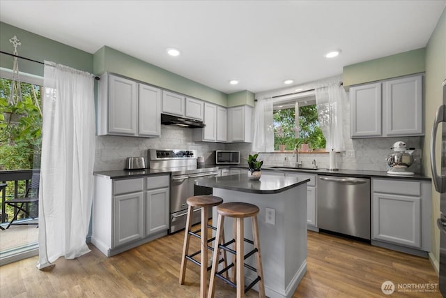 35632 158th St SE, Sultan, WA 98294 - kitchen featuring appliances with stainless steel finishes, under cabinet range hood, dark countertops, backsplash, and recessed lighting