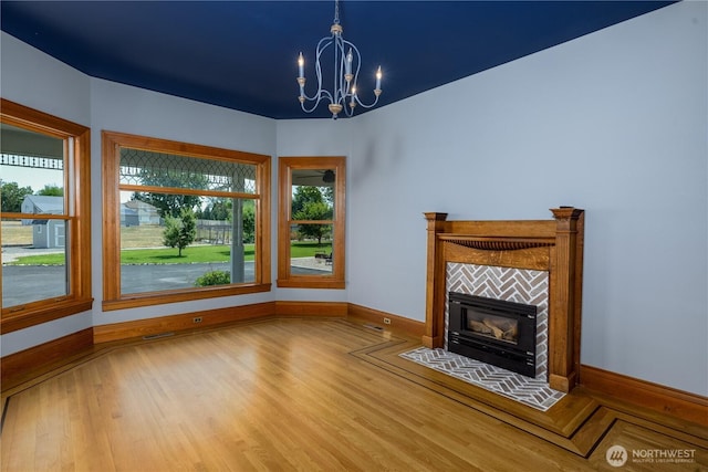 11801 Rd 5.6 NE, Moses Lake, WA 98837 - unfurnished living room with healthy amount of natural light, a chandelier, wood finished floors, and a fireplace