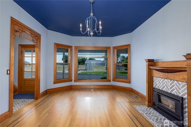 11801 Rd 5.6 NE, Moses Lake, WA 98837 - unfurnished dining area with wood finished floors, a chandelier, and a tiled fireplace