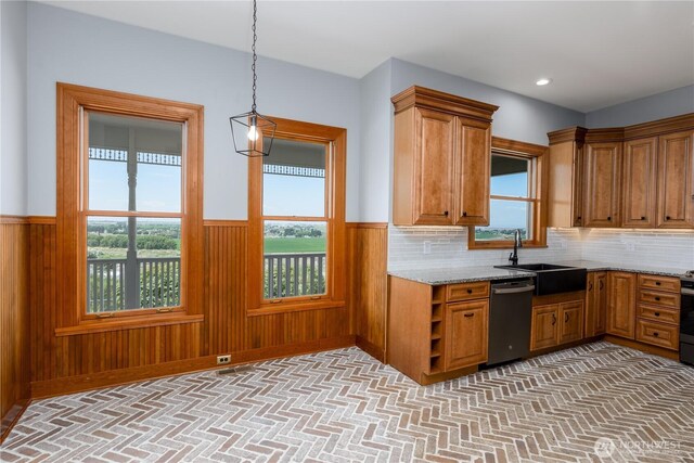 11801 Rd 5.6 NE, Moses Lake, WA 98837 - kitchen with stainless steel dishwasher, wainscoting, brown cabinets, light stone counters, and plenty of natural light
