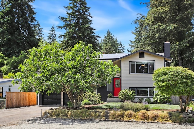 13045 28th Ave NE, Seattle, WA 98125 - view of front facade featuring driveway, solar panels, a chimney, and a garage