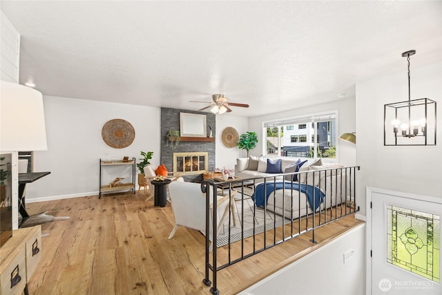 13045 28th Ave NE, Seattle, WA 98125 - living area featuring ceiling fan, light wood finished floors, a large fireplace, and a chandelier