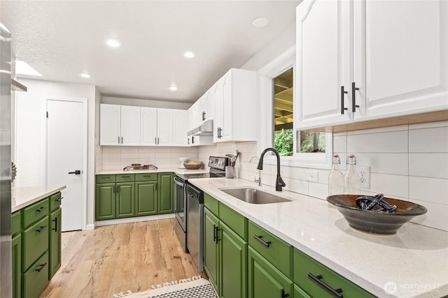13045 28th Ave NE, Seattle, WA 98125 - kitchen with green cabinets, appliances with stainless steel finishes, white cabinetry, light wood-style floors, and decorative backsplash