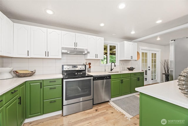 13045 28th Ave NE, Seattle, WA 98125 - kitchen featuring stainless steel appliances, under cabinet range hood, white cabinets, backsplash, and recessed lighting