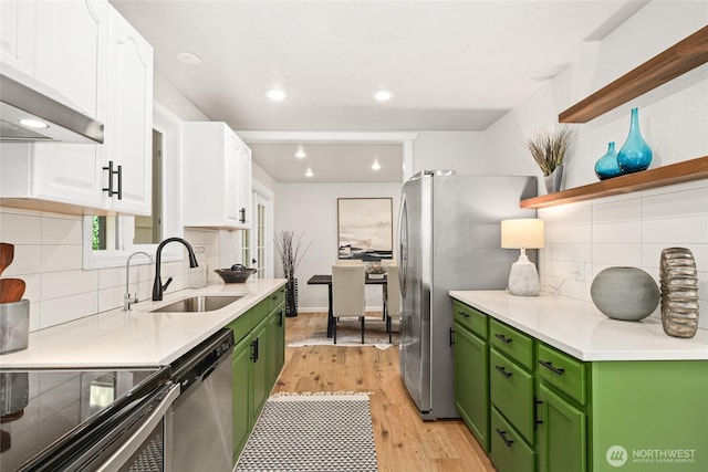 13045 28th Ave NE, Seattle, WA 98125 - kitchen featuring green cabinetry, appliances with stainless steel finishes, white cabinets, wall chimney exhaust hood, and recessed lighting