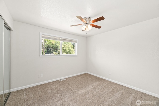 13045 28th Ave NE, Seattle, WA 98125 - unfurnished bedroom with a closet, carpet flooring, and a ceiling fan