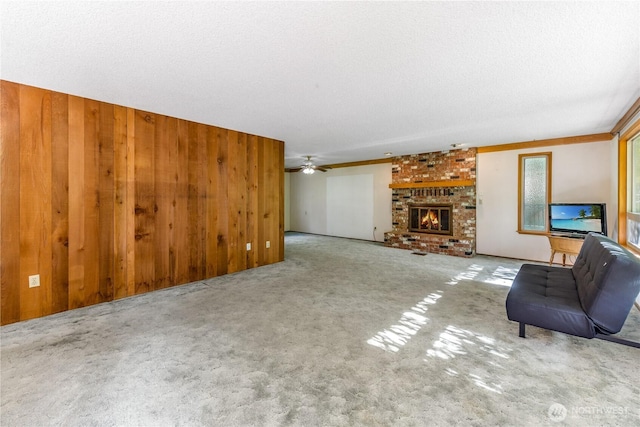 8419 121st St E, Puyallup, WA 98373 - unfurnished living room featuring carpet floors, wood walls, a brick fireplace, and ceiling fan