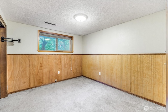 8419 121st St E, Puyallup, WA 98373 - unfurnished room with a textured ceiling, wood walls, a wainscoted wall, and carpet