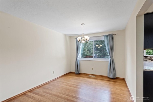 4128 S Lee St, Spokane, WA 99203 - unfurnished room featuring a chandelier, light wood finished floors, and plenty of natural light