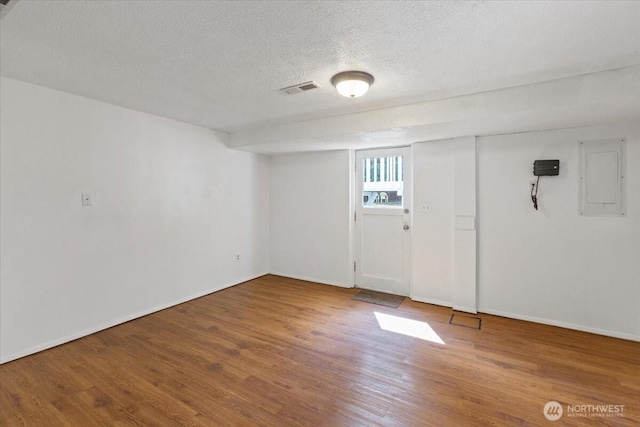 4128 S Lee St, Spokane, WA 99203 - below grade area with electric panel, wood finished floors, and a textured ceiling