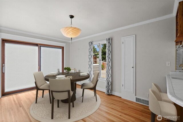 6903 Fauntleroy Way SW, Seattle, WA 98136 - dining room featuring light wood-style floors and crown molding