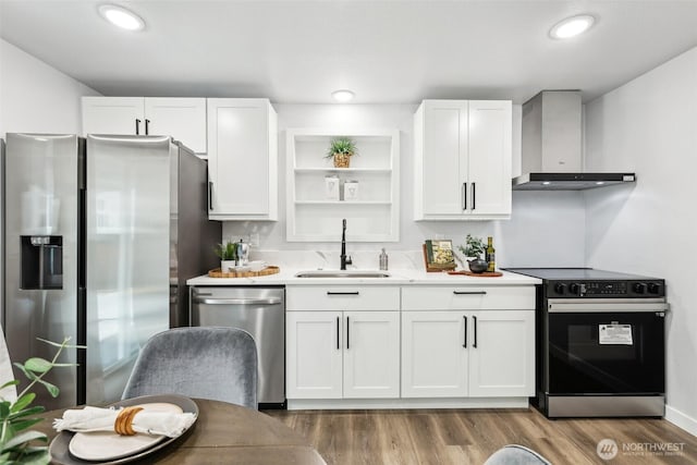 4715 S Cushman Ave, Tacoma, WA 98408 - kitchen with stainless steel appliances, wall chimney exhaust hood, white cabinets, light countertops, and wood finished floors