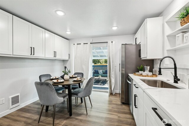 4715 S Cushman Ave, Tacoma, WA 98408 - kitchen with open shelves, light stone counters, white cabinets, dark wood-style floors, and recessed lighting