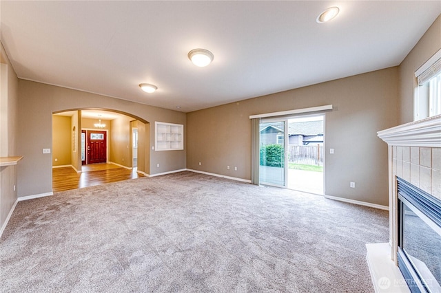 120 Petal Ln, Sequim, WA 98382 - unfurnished living room with carpet floors, arched walkways, healthy amount of natural light, and a fireplace